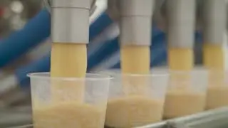 High-speed liquid dosing soup into a container using a SEALPAC Walking Beam