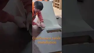 Senior installer installs leather-trimmed custom conference table。