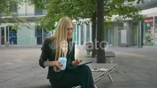 Young Business Woman Using Tablet and Drinking Coffee. Modern Executive Girl in Suit Sitting on ...