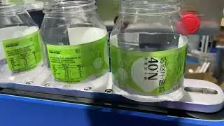 Automated Label Application and Shrinking System for Large Cylindrical Bottles.