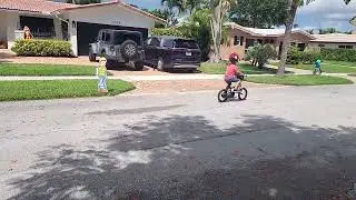 Children at play sign watches over kid that just had his bikes training wheels removed.