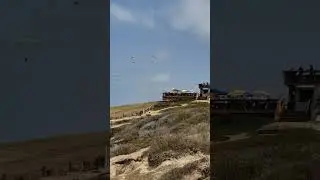 Парапланерист наблюдает за волнами на планерной площадке Торри Пайнс в Ла-Хойе, Сан-Диего, Калифо...