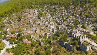 Kayakoy, Turkey. Drone view of ancient stone ruins in abandoned ghost town on mountain hill under...