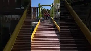 Cute 2 year old little girl enjoys riding down the roller slide