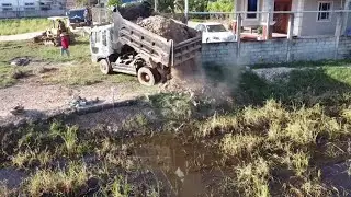 Start a new project by filling a water-filled rice field with a 5-ton dump truck and an D20P