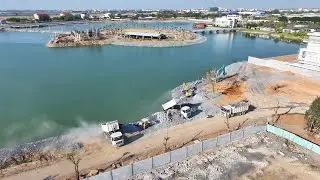 Trucks carrying rocks into the water and excavators sorting the rocks to make footpaths
