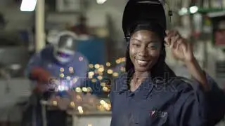 4K Portrait beautiful smiling female welder in metalwork shop. Slow motion.