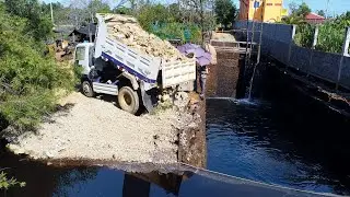 Bulldozer Power in action project pour stone into black water
