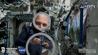 Astronauts Eytan Stibbe and Michael L&oacute;pez-Alegr&iacute;a creating a large water lens on the ISS