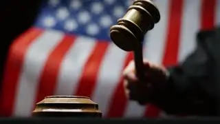 judge hammering with wooden gavel against waving