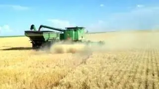 John Deere 9660 unloading in a Brent 1282 Grain Cart pulled by John Deere 9220