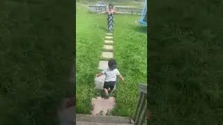 Toddler carefully rushes down the stairs, and around grandma to get to grandpa!