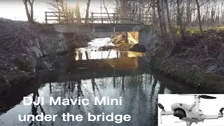 The DJI Mavic Mini drone is flying under the small bridge in Varese, Italy, in winter