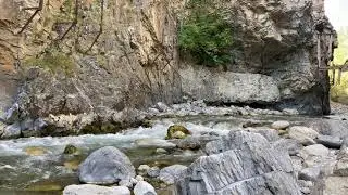 1 whole minute of a water stream flowing in a rotten valley.