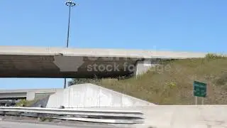 Slomo driving. Passing under concrete highway overpass late summer. Toronto HD driving stock video.