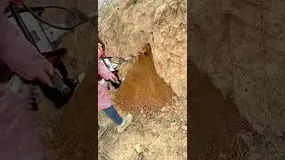 Drilling Into A Dirt Hill Using A Large Metal Auger Machine To Create A Hole In The Ground