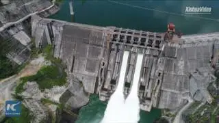 Amazing aerial view of waterfall, rainbow after flood gates open at power plant in SW China