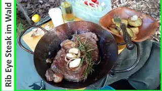 Рибай стейк на огне с жареным картофелем и салатом на открытом воздухе