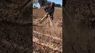 a man cleaning plastic in a dry farmland