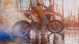 VideoVault Stock Video: Motocross motorcyclist takes off from a big puddle of water slow motion