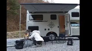 The young lady is camping outdoors alone in her luxurious motor home