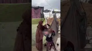Displaced Palestinian woman cries as winter floods her tent