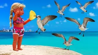 Que dia mais lindo! A bonequinha Emily está na praia e trouxe comidinha para os passarinhos!