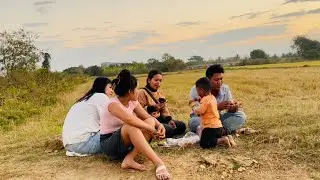 I'm at the rice field with my nieces, enjoying some beef sticks, chicken wings, and papaya