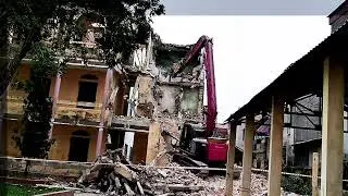 Skills in operating a KOBELCO SK 135 SR excavator for demolishing high-rise buildings.