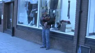 Busker playing bagpipes in Thornbury High Street - Street Musician