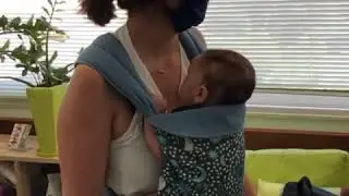 Newborn baby in a mei tai
