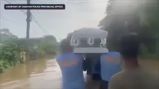 Police carry coffin in waist-high flood in Cagayan