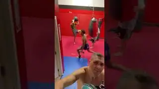 Front kicks on the heavybag while holding a medicine ball
