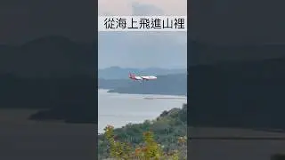 Airplane flying from the sea into the mountains