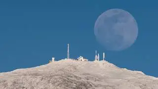 Moon Rises Behind the Snow Capped Peak of Mount Washington in New Hampshire