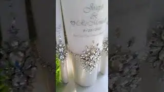 Decoration of wedding candles with rhinestones and text with the names and date of the wedding.
