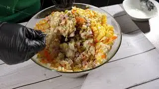The chef stirs the salad with a spoon.