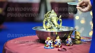 Person pouring milk over Ganesha idol during a Hindu religious ceremony