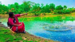 A cute girl is catching fish with a fishing rod using bait she collected from nature
