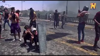 Anti-government protesters face off against riot police in Baghdad