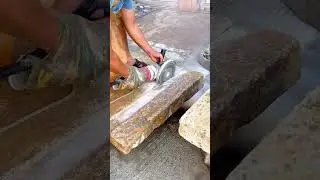 cutting a stone slab with an angle grinder by guiding the spinning blade along a straight line up
