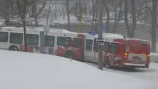 Articulated bus stuck on hill, snowstorm pulled up by towtruck