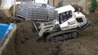 Track loader Liebherr 634 digging out concrete foundations
