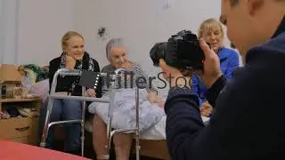 Family visiting elderly grandmother and taking photo with her