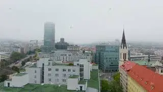 Camera is panning over the cityscape of Brno, Czech Republic. Skyscrapers and church of Saint Thomas