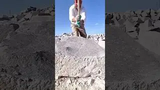 Skilled Stone Worker Precisely Splitting a Massive Quarry Block with Hand Tools Under a Bright Sun