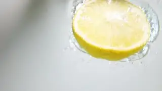 Half Lemon Drop Into Water Stock Video