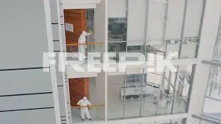 Distant View Of Two Cleaning Men Wearing Personal Protective Equipment Cleaning Stair Railings Insid