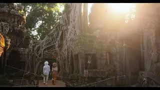 Tourist Couple Wandering Ta Prohm Temple Ruins Under Golden Sunlight