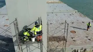 Crew from deck and engine department working together in installation of flood lights
